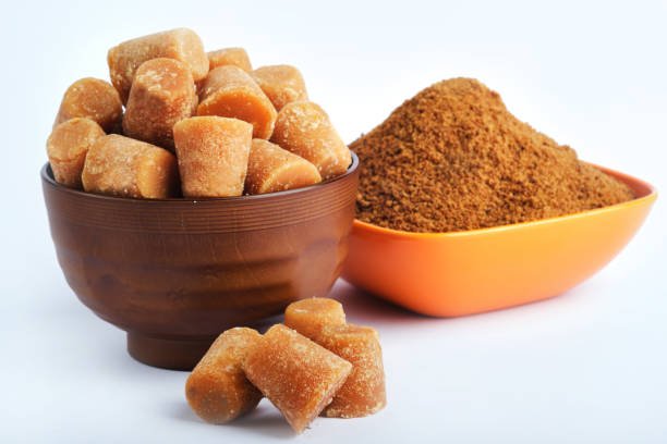 Organic Gur or Jaggery Powder and cubes, Jaggery is used as an ingredient in sweet and savoury dishes in the cuisines of India, Jaggery Powder is unrefined sugar obtained from concentrated sugarcane juice, Selective focus.